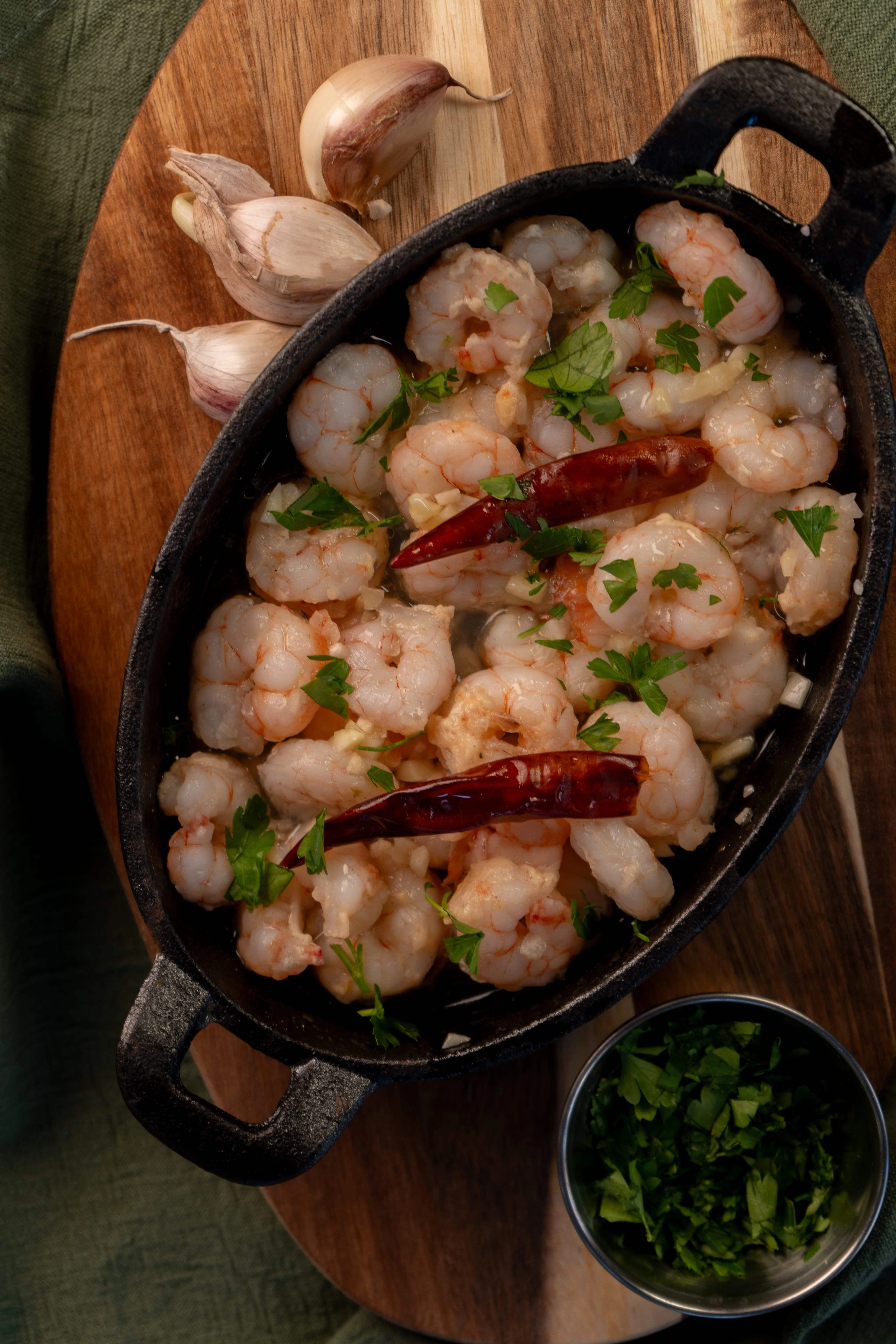 Gambas al ajillo - tapa de marisco Gambas al ajillo en cazuela con aceite de oliva